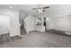 Open concept living space with neutral carpet, staircase, and view into the kitchen area at 923 E Agua Fria Ln, Avondale, AZ 85323