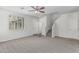Bright and open living room with carpet, a ceiling fan, and staircase access at 923 E Agua Fria Ln, Avondale, AZ 85323