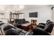 Open living area with plush black leather seating, a wooden coffee table, and access to the dining area at 9325 W Elwood St, Tolleson, AZ 85353
