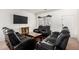 Cozy living room featuring plush black leather seating, a wooden coffee table, and ample natural light at 9325 W Elwood St, Tolleson, AZ 85353