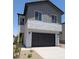 Two-story home featuring a black two-car garage and low-maintenance desert landscaping at 9408 E Sequence Ave, Mesa, AZ 85212