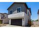 Charming two-story home featuring grey siding, a stucco base, dark garage door, and well-manicured landscaping at 9408 E Sequence Ave, Mesa, AZ 85212