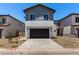Street view of stucco homes with grey siding, dark garage doors, minimal desert landscaping, and concrete driveways at 9408 E Sequence Ave, Mesa, AZ 85212