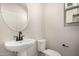 Half bathroom with pedestal sink, oval mirror, and toilet at 9408 E Sequence Ave, Mesa, AZ 85212