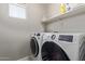 Bright laundry room featuring modern, front-load washer and dryer, and practical shelving at 9412 S 34Th Dr, Laveen, AZ 85339
