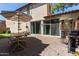Patio area with brick flooring, dining set, umbrella, gas grill, and sliding glass doors at 9412 S 34Th Dr, Laveen, AZ 85339