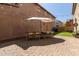 Paver patio featuring outdoor dining set, umbrella, string lights, and green turf area at 9412 S 34Th Dr, Laveen, AZ 85339