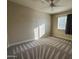Bright bedroom featuring neutral paint, a ceiling fan, and a large window letting in natural light at 1010 N Osprey Ct, Gilbert, AZ 85234