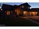 Attractive two story home with tile roof, three-car garage, and green lawn at twilight at 1010 N Osprey Ct, Gilbert, AZ 85234
