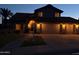 Stunning two-story home at dusk featuring a well-manicured lawn and a three-car garage at 1010 N Osprey Ct, Gilbert, AZ 85234