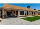 A backyard with an outdoor seating area, landscaping rocks, and synthetic grass at 10211 W Hazelwood Ave, Phoenix, AZ 85037