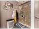 A bathroom with a glass-enclosed tiled shower, decor, and a grey accent wall at 10211 W Hazelwood Ave, Phoenix, AZ 85037