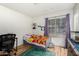 A bedroom with a window, wood-look flooring, bed, and black desk at 10211 W Hazelwood Ave, Phoenix, AZ 85037