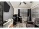 A home office with a ceiling fan, TV, grey accent wall, black desk and chair, and dark wood-look flooring at 10211 W Hazelwood Ave, Phoenix, AZ 85037