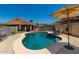 Backyard pool featuring clear blue water, patio, lounge chairs and umbrellas, offering a serene outdoor retreat at 10211 W Hazelwood Ave, Phoenix, AZ 85037