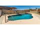 Backyard pool featuring lounge chairs, an umbrella, and a baja shelf, creating an ideal outdoor oasis at 10211 W Hazelwood Ave, Phoenix, AZ 85037