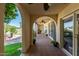 Arched patio with tile flooring overlooks outdoor seating area with lush greenery and a fountain at 1036 N Sierra Hermosa Dr, Litchfield Park, AZ 85340