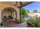 Arched patio with tile flooring and outdoor seating overlooks lush greenery and mature shade trees at 1036 N Sierra Hermosa Dr, Litchfield Park, AZ 85340