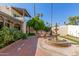 Backyard patio featuring a beautiful fountain and outdoor dining space with palm trees and blue sky at 1036 N Sierra Hermosa Dr, Litchfield Park, AZ 85340