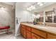 Bathroom featuring double sinks, wood cabinets, granite countertops, and a large decorative mirror at 1036 N Sierra Hermosa Dr, Litchfield Park, AZ 85340