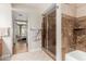 Bathroom featuring a glass shower, tile accents, and a view into the main bedroom at 1036 N Sierra Hermosa Dr, Litchfield Park, AZ 85340