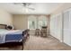 Bedroom featuring carpeted floors, a ceiling fan, two arched windows, and closet with sliding doors at 1036 N Sierra Hermosa Dr, Litchfield Park, AZ 85340