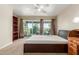 Bedroom with sliding glass door to balcony, ceiling fan, and built-in shelving and desk at 1036 N Sierra Hermosa Dr, Litchfield Park, AZ 85340