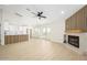 Bright living room featuring wood floors, a ceiling fan, fireplace, and open access to the modern kitchen at 1102 W Peoria Ave # 17, Phoenix, AZ 85029