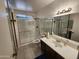Well-lit bathroom featuring a walk-in shower, modern vanity and large mirror at 11216 N 52Nd Ave, Glendale, AZ 85304