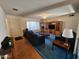 Spacious living room with a large window for natural light, comfortable seating, and a vintage entertainment center at 11216 N 52Nd Ave, Glendale, AZ 85304