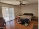 Spacious main bedroom featuring wood-look floors, ceiling fan, and a sliding door to the backyard at 11216 N 52Nd Ave, Glendale, AZ 85304