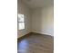 Bright bedroom featuring new flooring and a large window at 12586 W Amelia Ave, Avondale, AZ 85392
