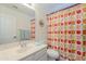 Bright bathroom showcasing a large mirror, tiled floors, vibrant shower curtain and sink basin at 17293 N Ponca Way, Surprise, AZ 85374