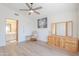 Bright bedroom featuring modern ceiling fan, light wood floors, and direct access to ensuite bathroom at 17293 N Ponca Way, Surprise, AZ 85374