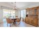 Dining area features an elegant chandelier, desert views through sliding glass doors and a dark wood china cabinet at 17293 N Ponca Way, Surprise, AZ 85374