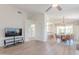 Open-concept living space with wood floors, TV area and view into kitchen and dining area at 17293 N Ponca Way, Surprise, AZ 85374