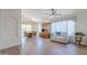 Spacious living room with wood floors, large windows, and furniture arrangement, connected to dining area at 17293 N Ponca Way, Surprise, AZ 85374