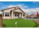 A well manicured backyard with putting green and covered patio with outdoor seating for entertaining at 17909 W Agave Rd, Goodyear, AZ 85338