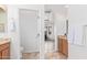 Bright bathroom featuring a wood vanity, tile floors and an arched entryway to the living space at 17909 W Agave Rd, Goodyear, AZ 85338