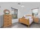 Charming bedroom with wood bed frame, matching nightstands and dresser, and contemporary ceiling fan at 17909 W Agave Rd, Goodyear, AZ 85338