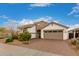 Beautiful single-story home with brick accents and a two-car garage and well manicured yard at 17909 W Agave Rd, Goodyear, AZ 85338