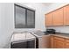 Well-equipped laundry room with new washer and dryer, storage cabinets, and natural light at 17909 W Agave Rd, Goodyear, AZ 85338