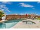 Backyard pool and spa area with lounge chairs, rock waterfall feature, and basketball hoop at 17909 W Agave Rd, Goodyear, AZ 85338