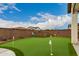 Backyard putting green with views of the neighborhood fence and lush landscaping at 17909 W Agave Rd, Goodyear, AZ 85338