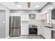 Updated kitchen featuring stainless steel appliances, white cabinetry, mosaic tile backsplash, and modern countertops at 18 E Hermosa Dr # 18, Tempe, AZ 85282