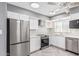 Updated kitchen featuring stainless steel appliances, white cabinetry, mosaic tile backsplash, and modern countertops at 18 E Hermosa Dr # 18, Tempe, AZ 85282
