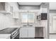 Updated kitchen featuring stainless steel appliances, white cabinetry, mosaic tile backsplash, and modern countertops at 18 E Hermosa Dr # 18, Tempe, AZ 85282