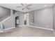 Cozy living room featuring new carpet, ceiling fan, staircase, and a large window with decorative curtains at 18 E Hermosa Dr # 18, Tempe, AZ 85282