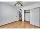 Bedroom with wood floors, standard closet with sliding doors, and access to the staircase at 1822 W Marlette Ave, Phoenix, AZ 85015