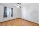 Bedroom with wood floors, ceiling fan, and a large window with patterned curtains at 1822 W Marlette Ave, Phoenix, AZ 85015